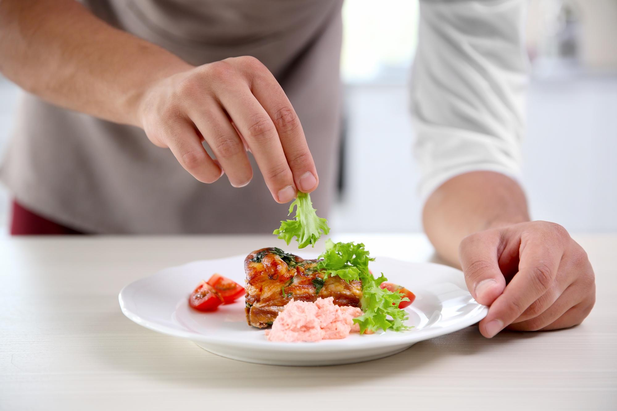 chef plating quick dish in a small kitchen